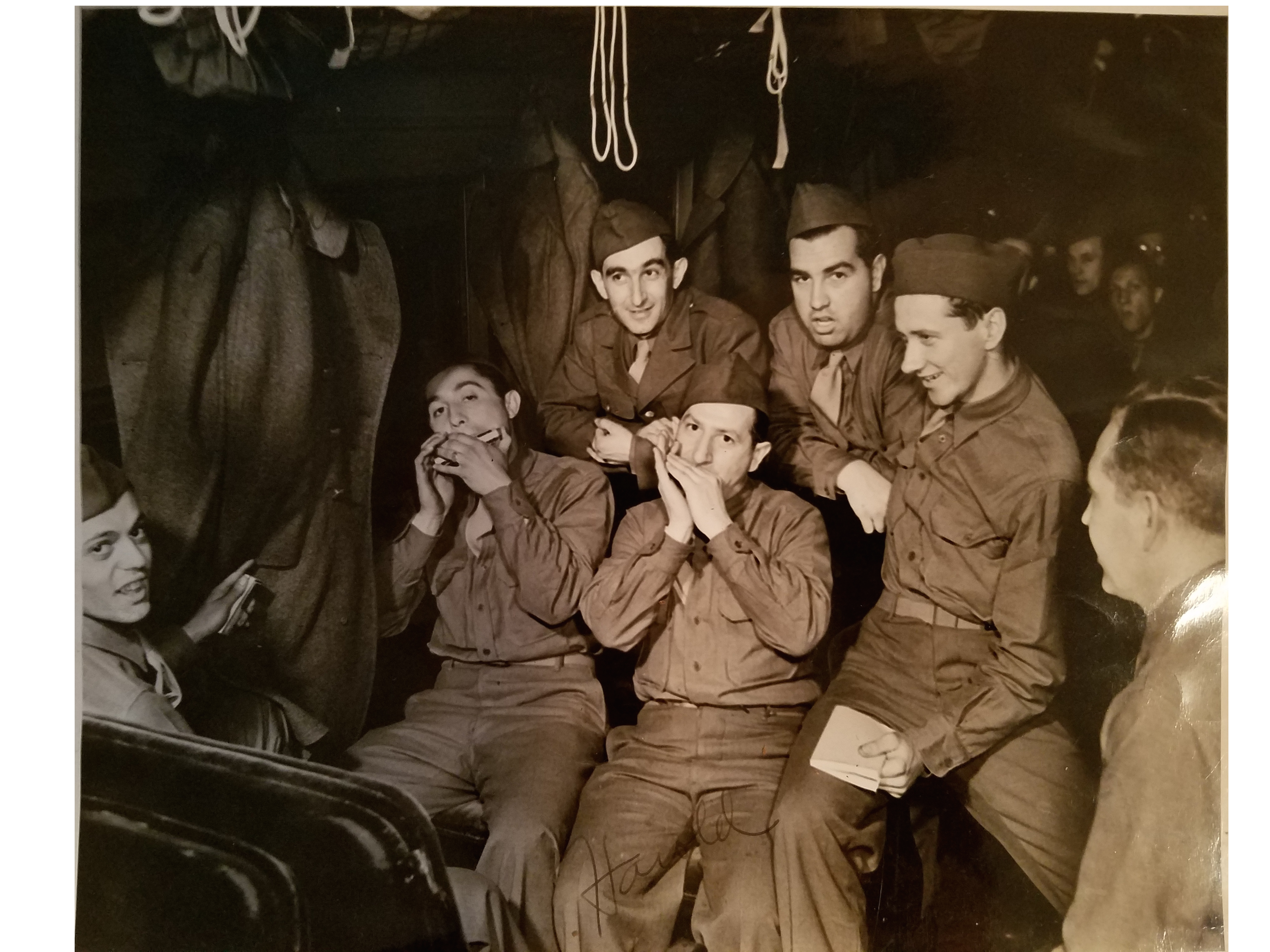 Harold in the Army, playing harmonica with crew